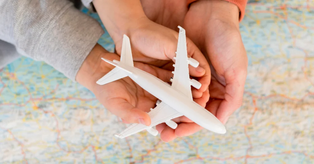 Symbolic image of care and travel planning (hands holding a plane over a map) used to illustrate how AI chatbots improve customer experience and protection in travel insurance.
