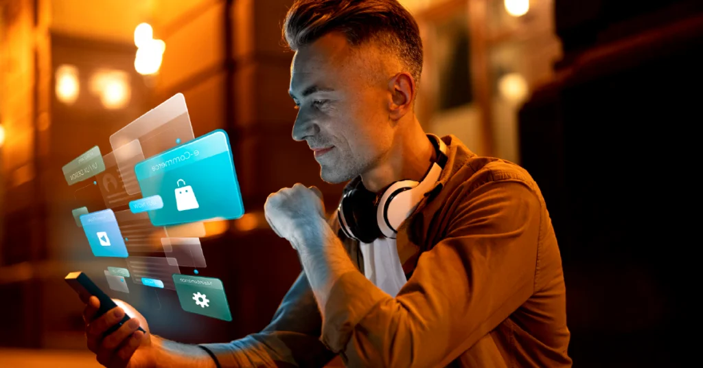 A man interacting with his smartphone and hovering holographic interfaces displaying 'e-Commerce' and 'shopping' icons, illustrating user-centric conversational AI design to lead to a successful sale in e-commerce.